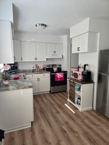 a kitchen with kitchen island a sink a stove and refrigerator