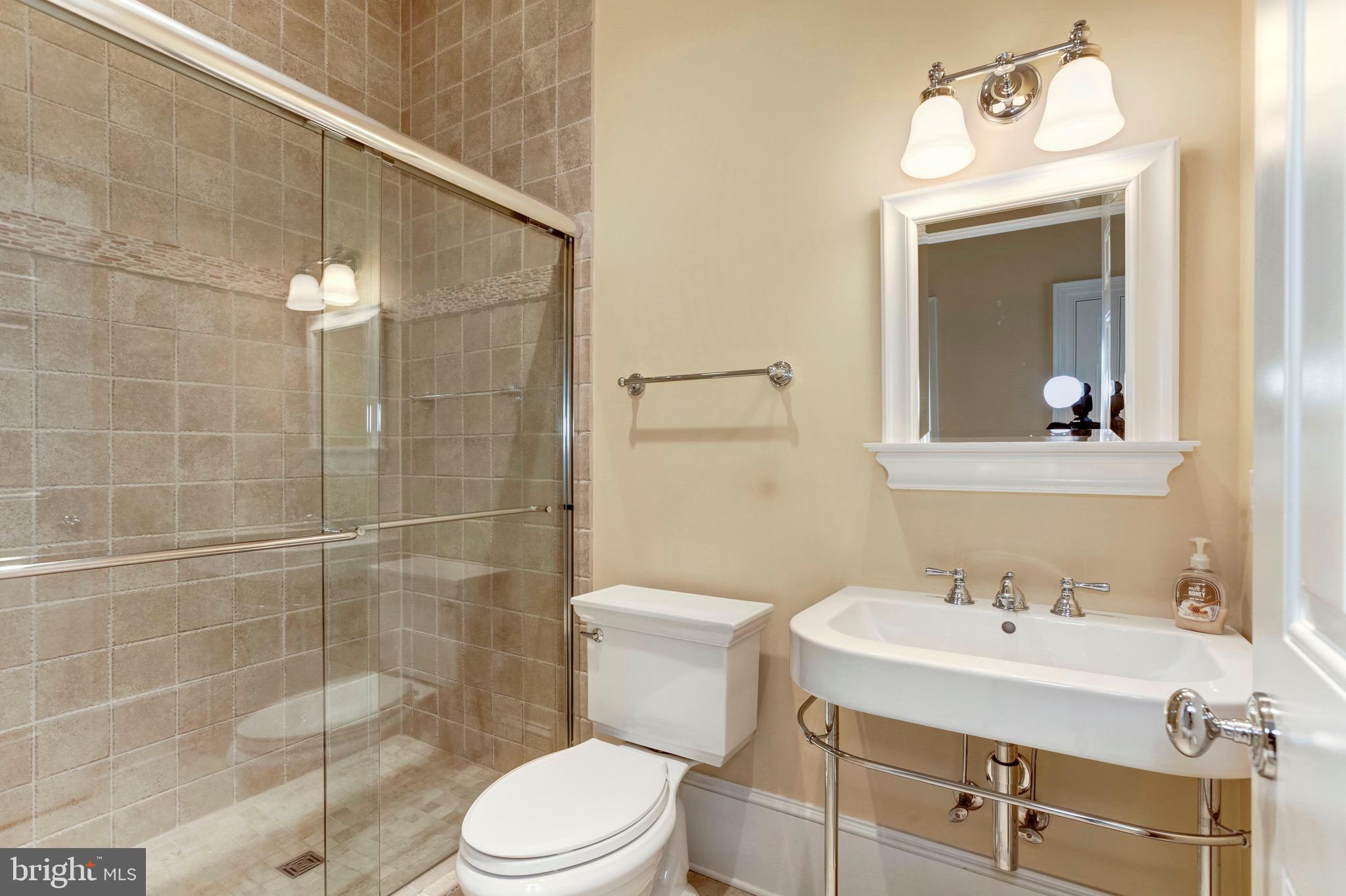 9809 Newhall Road Potomac, MD 20854 - Photo 15 of 37 a bathroom with a sink a toilet and shower