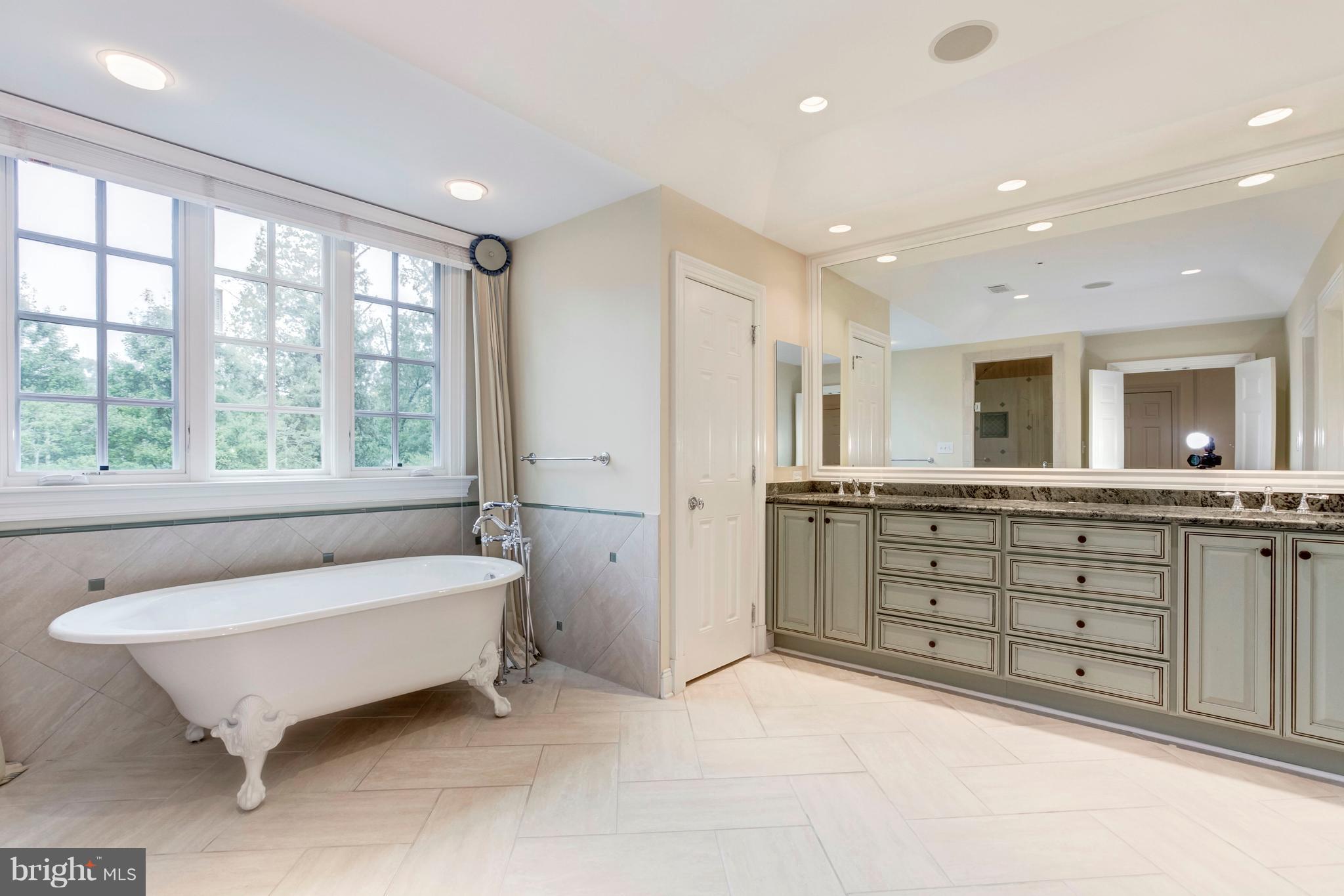 9809 Newhall Road Potomac, MD 20854 - Photo 17 of 37 a spacious bathroom with a double vanity sink tub and mirror