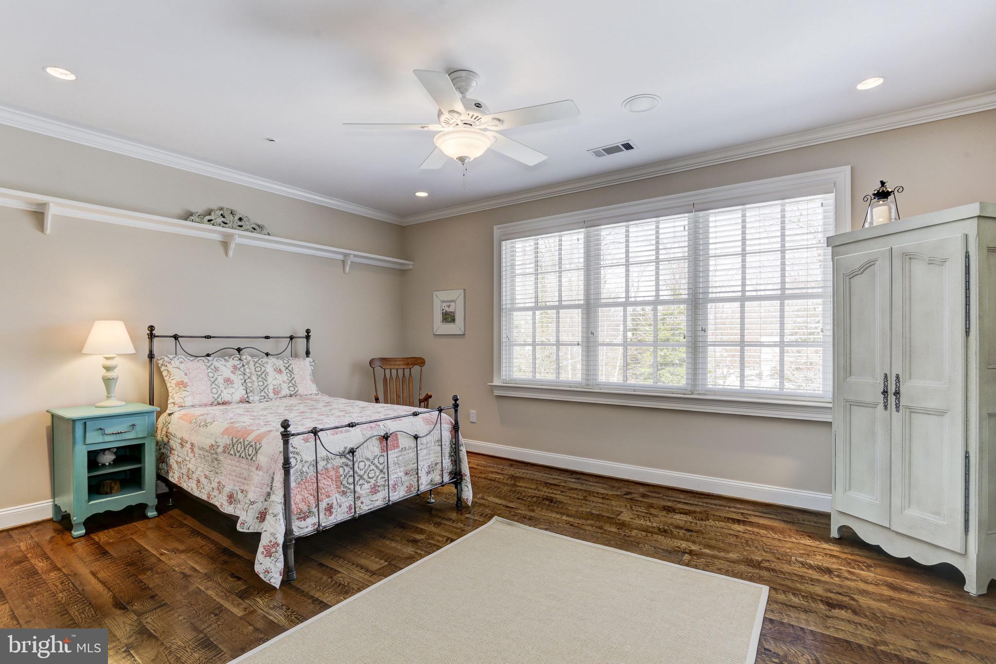 9809 Newhall Road Potomac, MD 20854 - Photo 21 of 37 a bedroom with a large bed and a chandelier