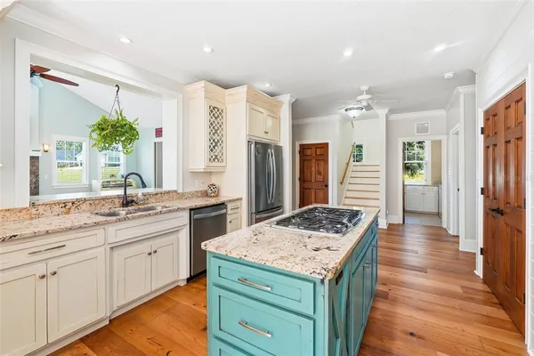 a kitchen with stainless steel appliances granite countertop a refrigerator a stove and a wooden floors