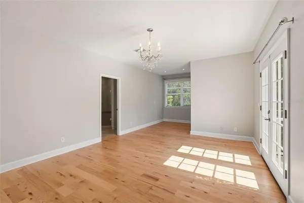 a view of an empty room with a window and kitchen view