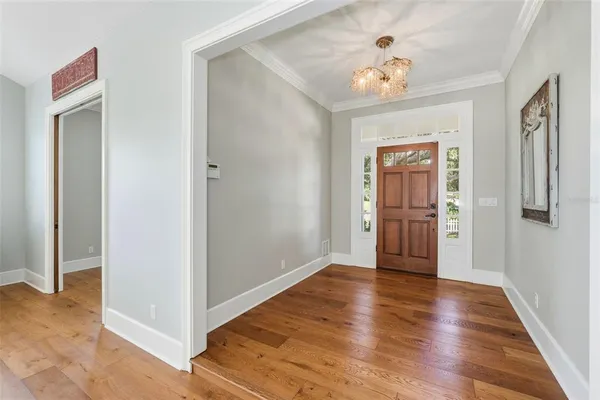 a view of a hallway with wooden floor and a bathroom