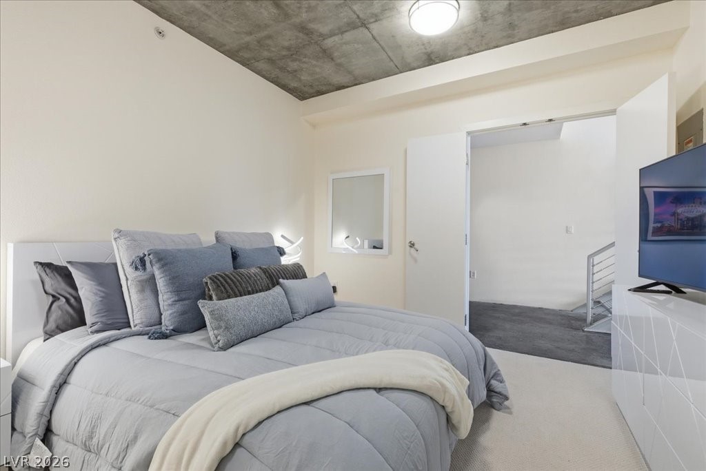 360 East Desert Inn Road, Unit 604 Las Vegas, NV 89109 - Photo 15 of 28 An inviting sleeping space with high ceilings and soft carpet, leading to a modern, open-concept area.