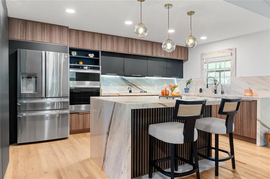 20107 Starry Street Orlando, FL 32833 - Photo 10 of 59 a kitchen with stainless steel appliances a dining table chairs refrigerator sink and stove