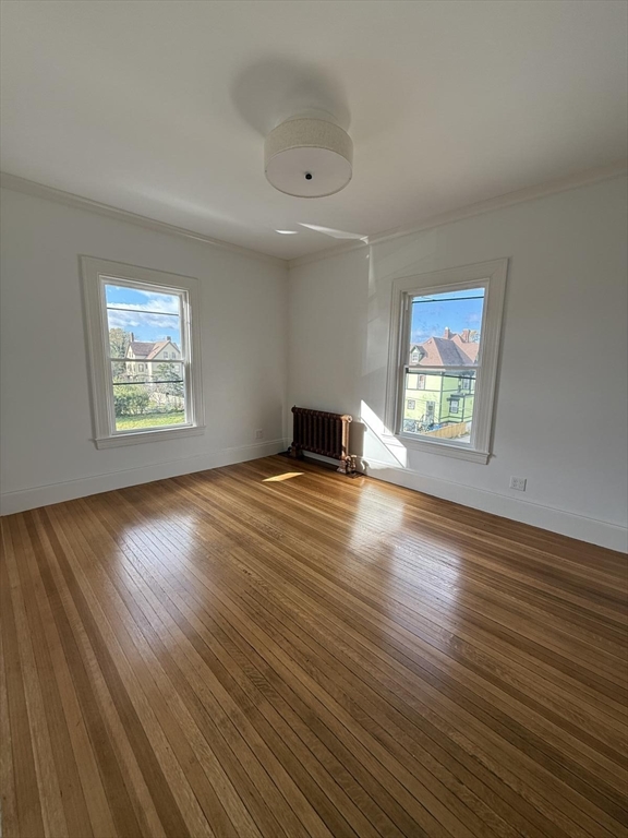 72 Belmont Street, Unit 1 Fall River, MA 02720 - Photo 17 of 20 a view of an empty room with wooden floor and a window