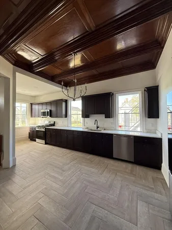a large kitchen with stainless steel appliances kitchen island granite countertop a large counter top and a microwave