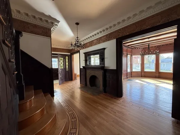 a view of an entryway with wooden floor and a fireplace