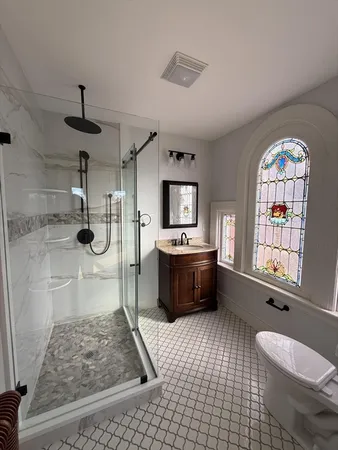 a bathroom with a sink a toilet a mirror and window