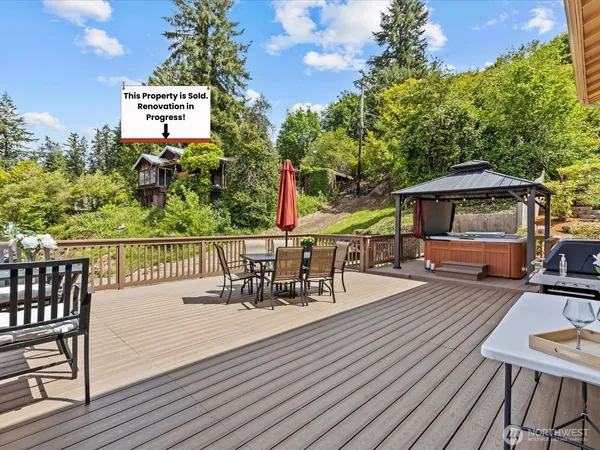 a view of a roof deck with table and chairs a barbeque with wooden floor and fence
