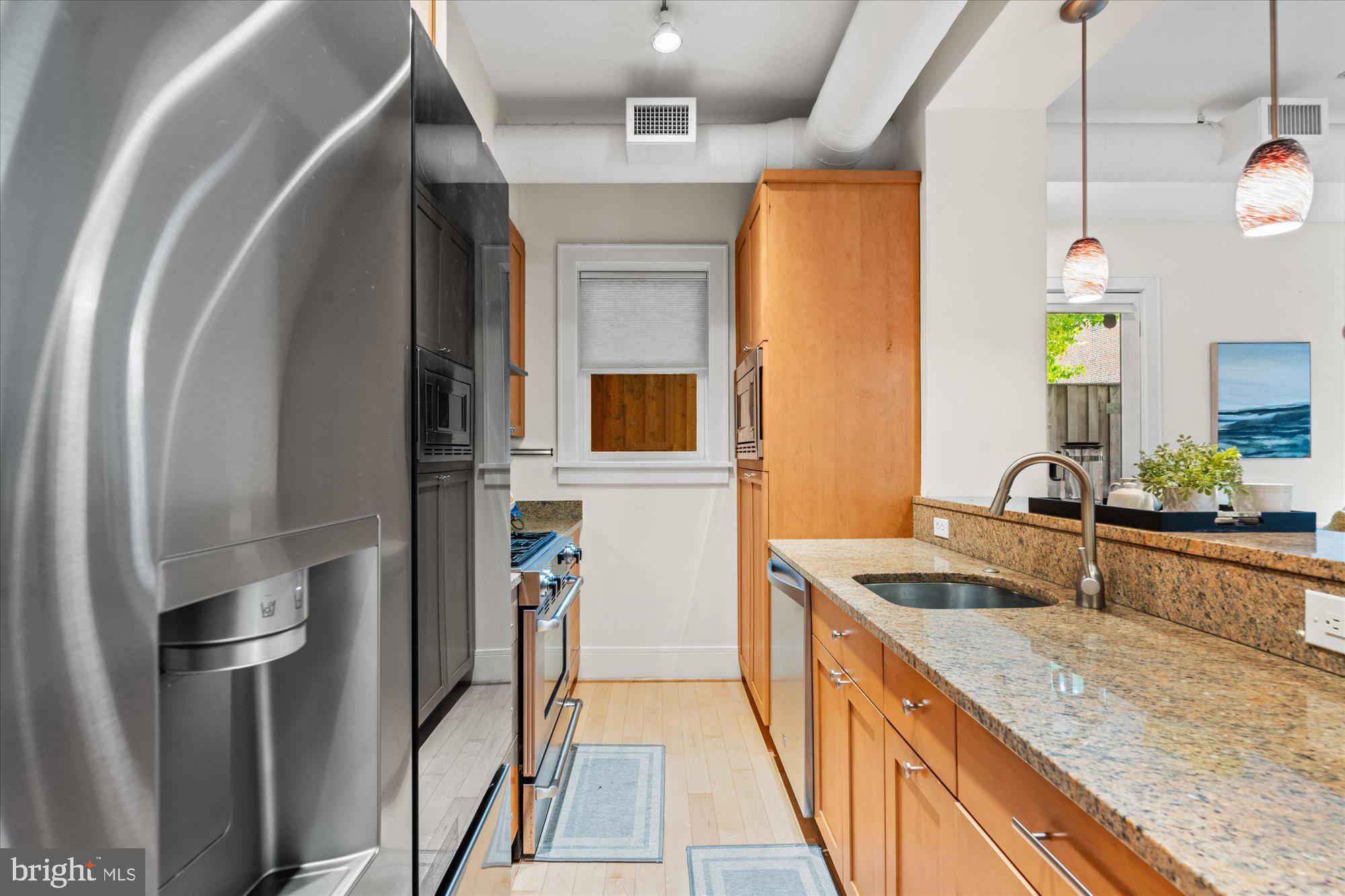 1817 Swann Street Northwest, Unit B Washington, DC 20009 - Photo 11 of 34 a kitchen with stainless steel appliances granite countertop a sink and a refrigerator