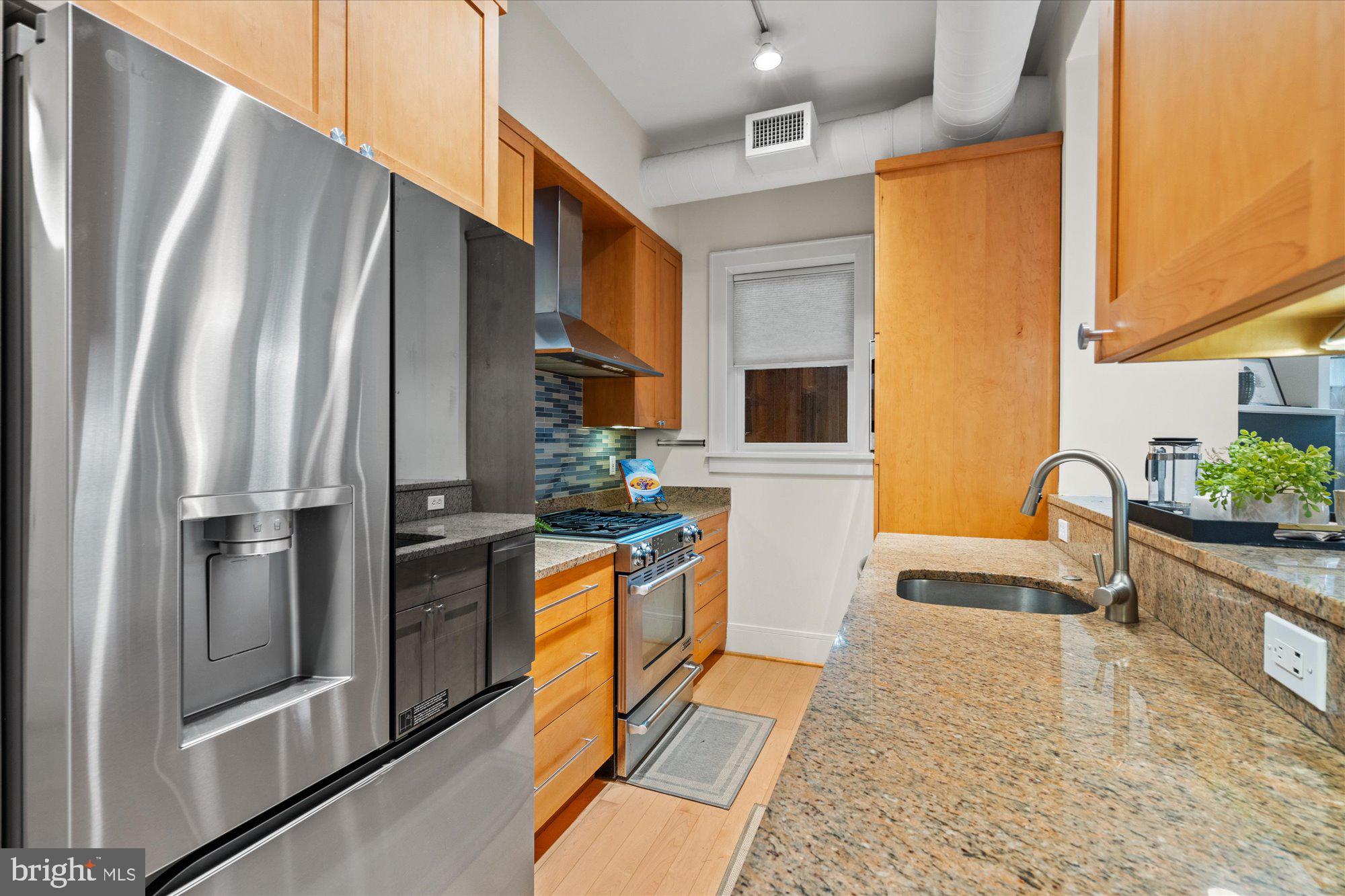 1817 Swann Street Northwest, Unit B Washington, DC 20009 - Photo 6 of 34 a kitchen with stainless steel appliances granite countertop a refrigerator a stove and a sink
