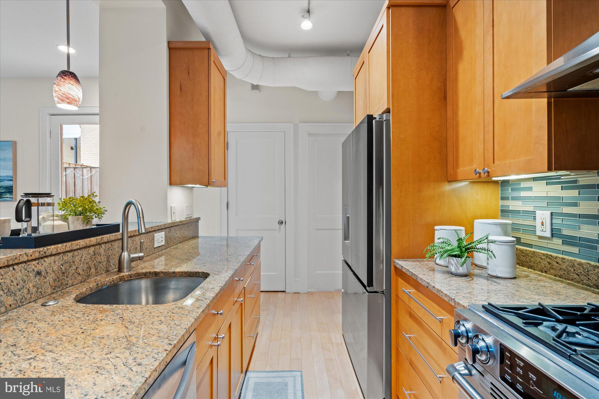 1817 Swann Street Northwest, Unit B Washington, DC 20009 - Photo 10 of 34 a kitchen with stainless steel appliances granite countertop a sink stove and refrigerator