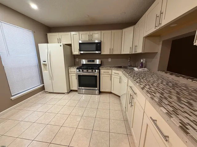 a kitchen with stainless steel appliances granite countertop a refrigerator sink and stove