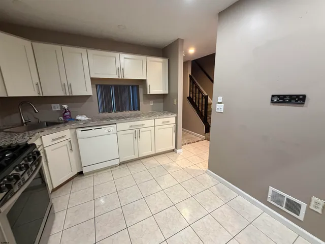 a kitchen with white cabinets a sink and white appliances