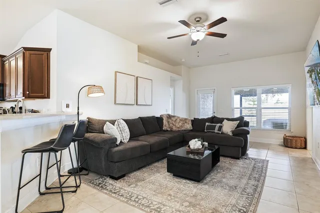 a living room with furniture a chandelier and a window