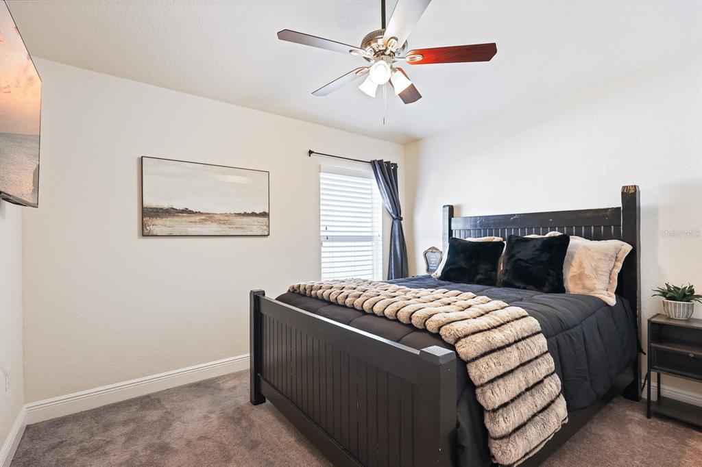 14510 Haddon Mist Drive Wimauma, FL 33598 - Photo 21 of 39 a bedroom with a bed and a chandelier