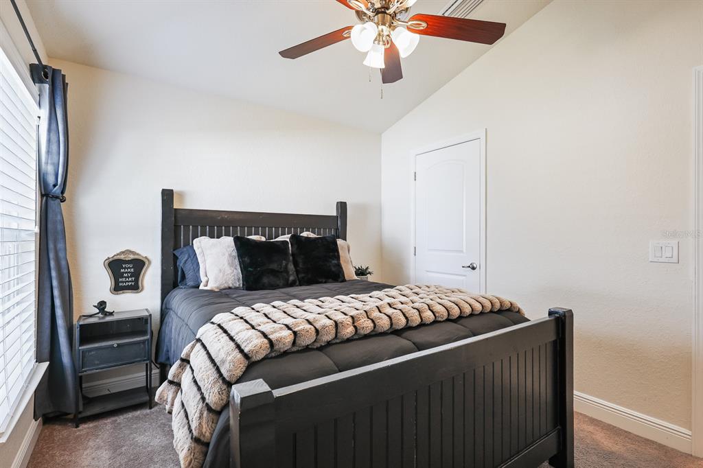 14510 Haddon Mist Drive Wimauma, FL 33598 - Photo 22 of 39 a bedroom with a bed and a chandelier