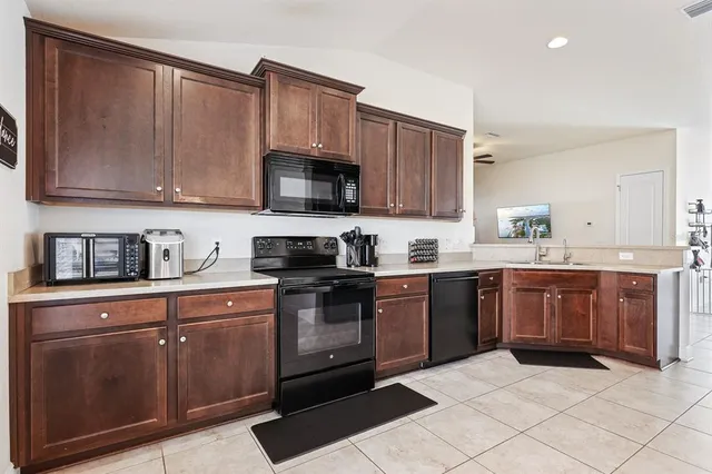 a kitchen with stainless steel appliances granite countertop a stove microwave and sink