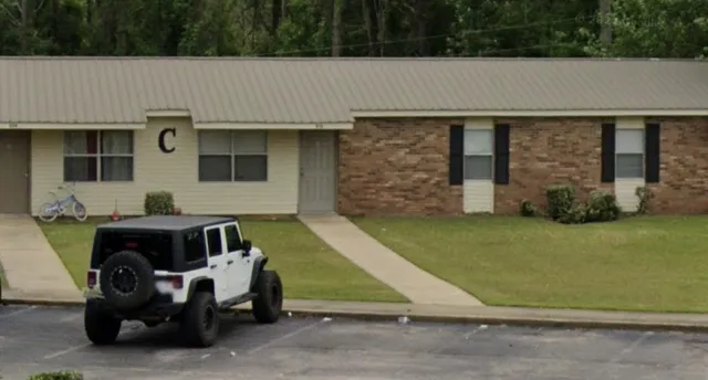 a front view of a house with a garden and plants