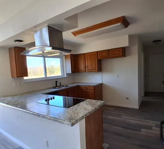 a kitchen with stainless steel appliances granite countertop a sink a stove and a wooden cabinets