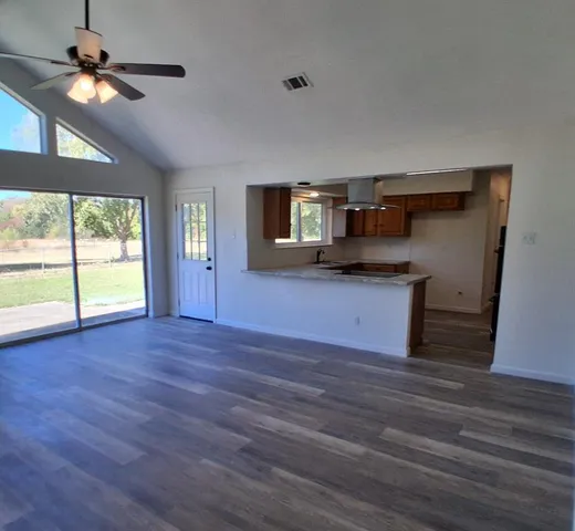 a kitchen with granite countertop wooden floors and wide window