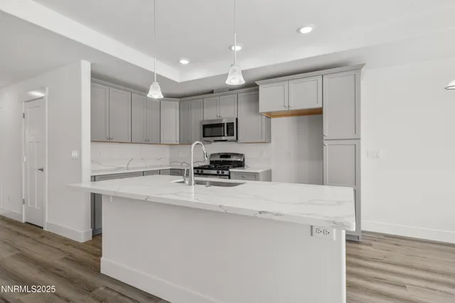 a kitchen with kitchen island a sink stainless steel appliances and cabinets