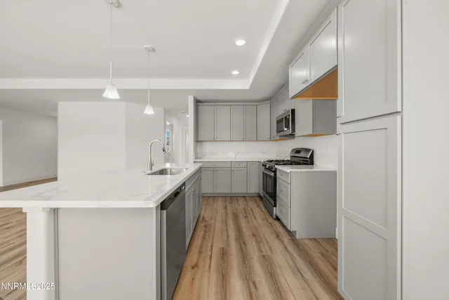 a kitchen with a sink a counter top space stainless steel appliances and cabinets