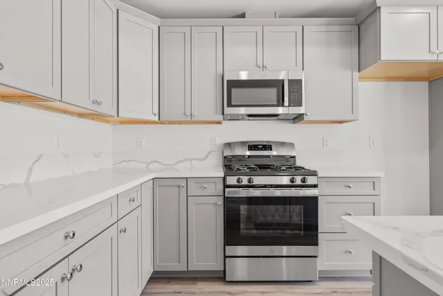 a kitchen with white cabinets and stainless steel appliances