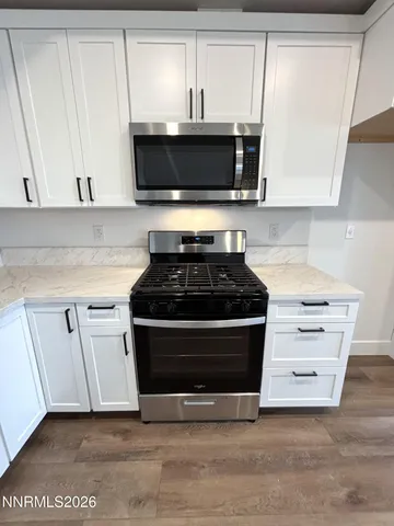 a kitchen with stainless steel appliances a stove a microwave and cabinets
