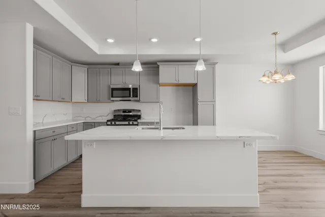 a kitchen with kitchen island white cabinets and stainless steel appliances