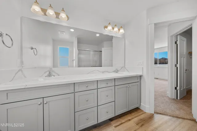 a bathroom with double vanity sinks a vanity a lamp and a mirror