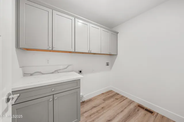 a view of a storage and utility room with wooden floor