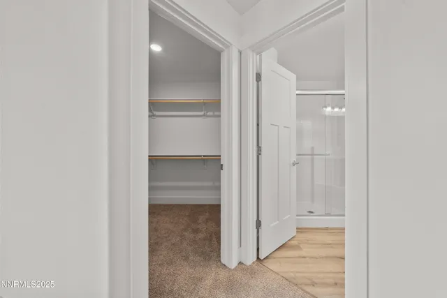 a view of an empty room with closet and a bathroom