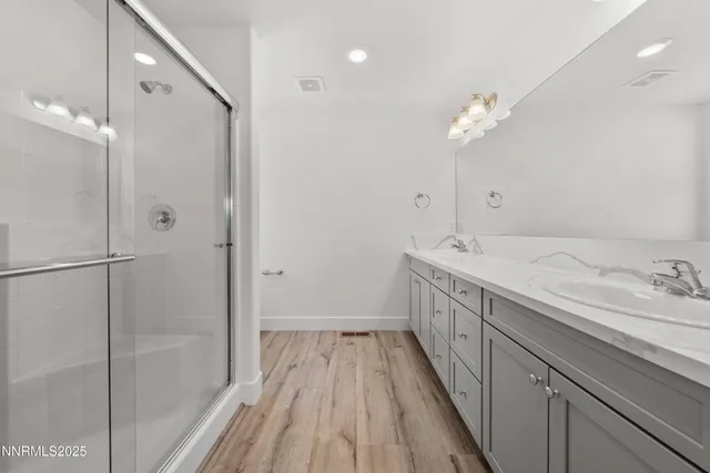 a bathroom with a double vanity sink a mirror and a shower