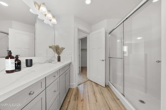 a bathroom with a double vanity sink mirror and shower