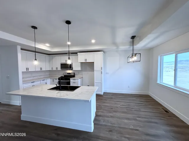 a kitchen with a stove a window and wooden floor