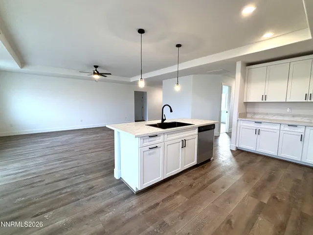 a kitchen with stainless steel appliances granite countertop a sink a stove and a wooden floors