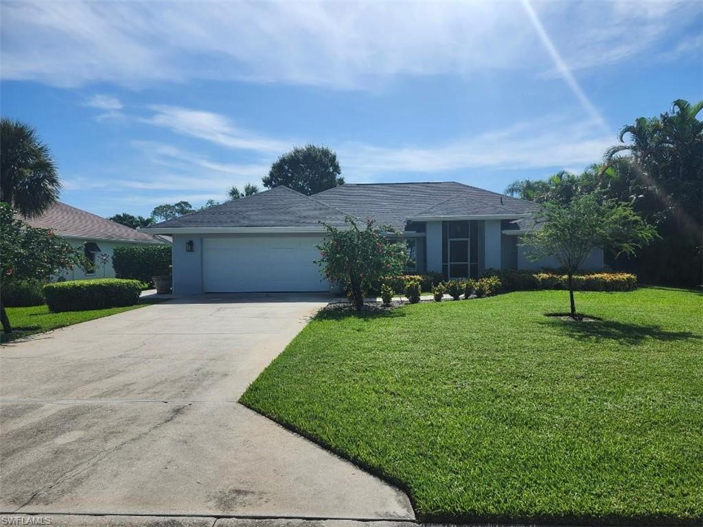 Ranch-style house featuring a front yard, an attached garage, concrete driveway, and stucco siding