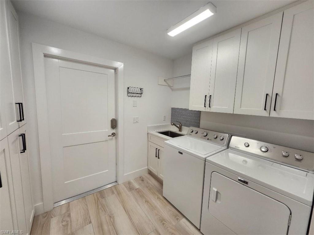 512 Raven Way Naples, FL 34110 - Photo 16 of 20 Washroom with cabinet space, washing machine and clothes dryer, and light wood-style floors