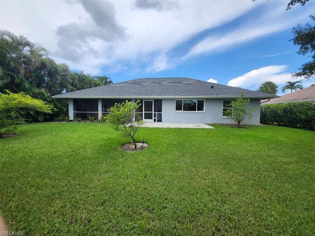 512 Raven Way Naples, FL 34110 - Photo 18 of 20 Back of house featuring stucco siding, a yard, a sunroom, and a patio area