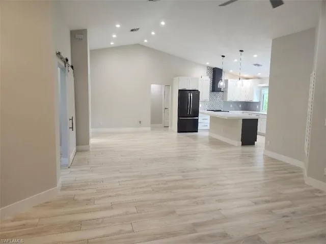 a view of kitchen with kitchen island refrigerator sink and wooden floor
