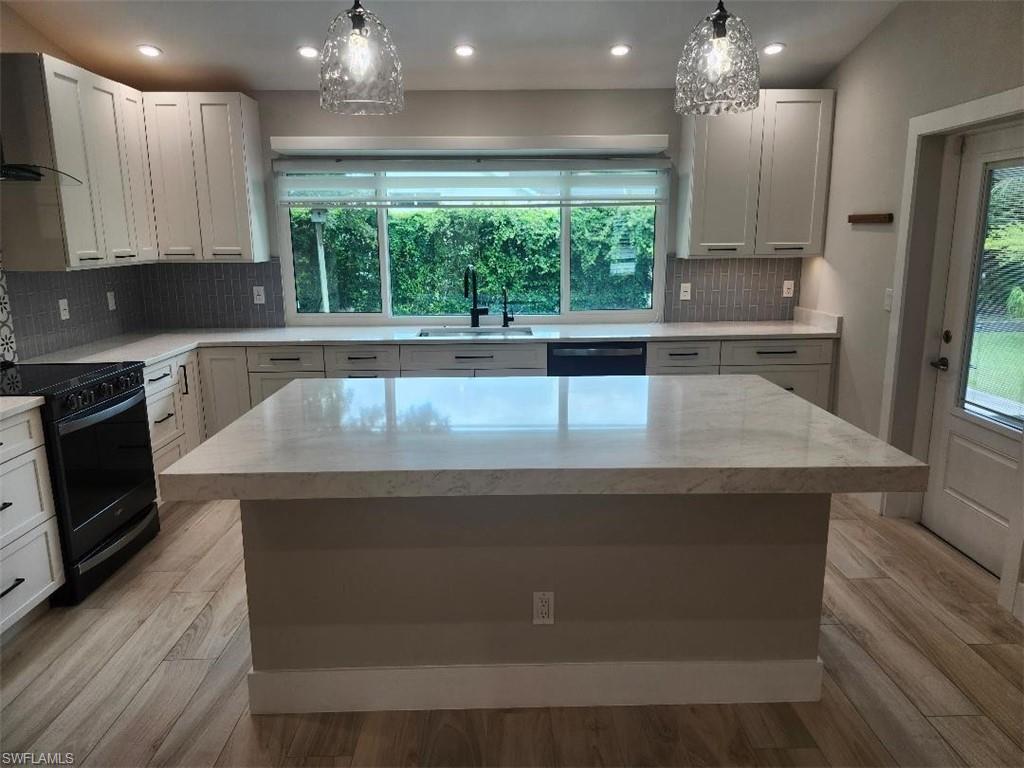 512 Raven Way Naples, FL 34110 - Photo 4 of 20 Kitchen with healthy amount of natural light, decorative backsplash, recessed lighting, and light wood-style flooring