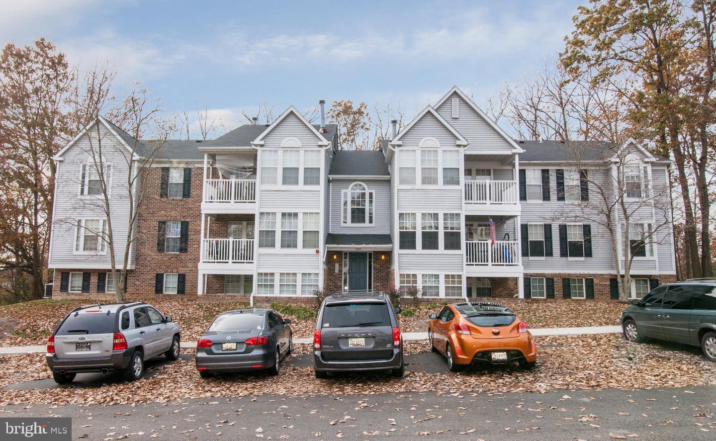 a front view of a building with cars parked