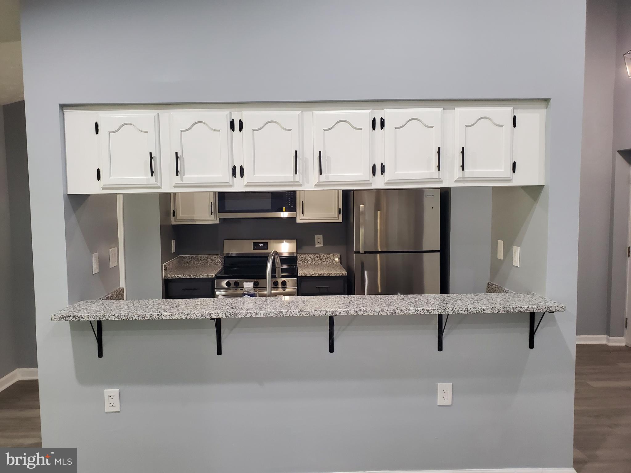 1304 Clover Valley Way, Unit K Edgewood, MD 21040 - Photo 4 of 10 a kitchen with stainless steel appliances kitchen island granite countertop a refrigerator a sink and white cabinets