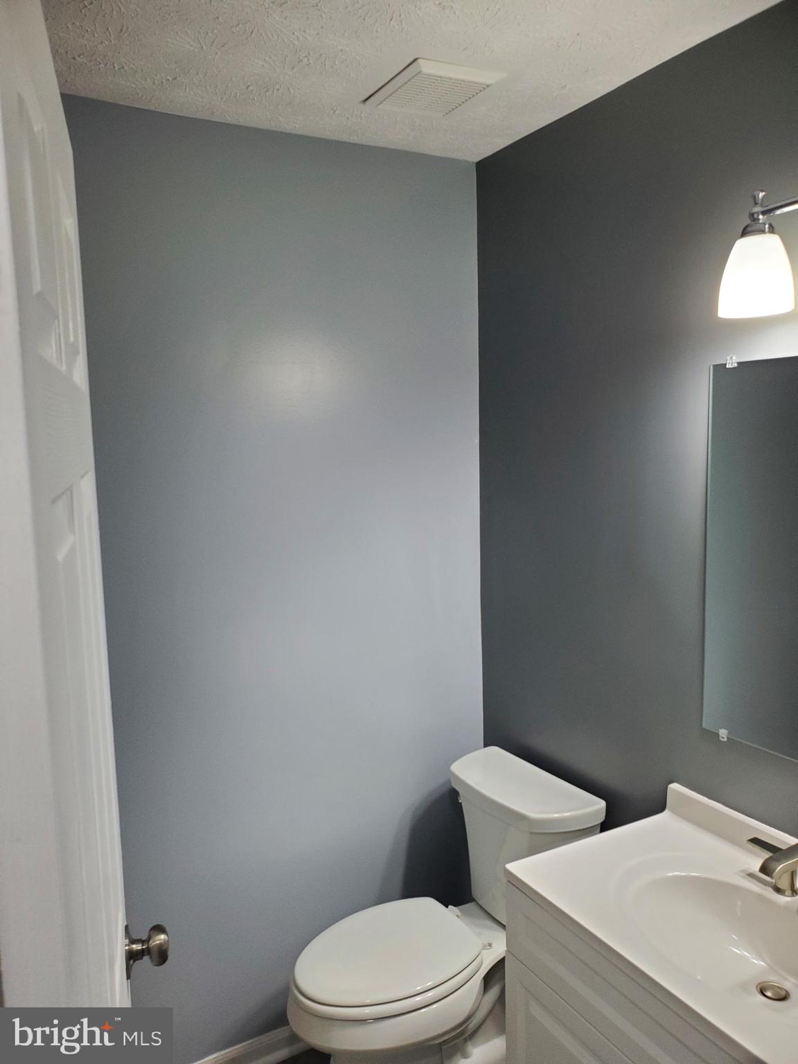 1304 Clover Valley Way, Unit K Edgewood, MD 21040 - Photo 8 of 10 a white toilet sitting next to a bathroom sink and vanity