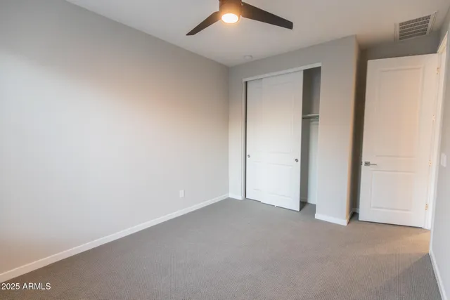 an empty room with a window and a fan