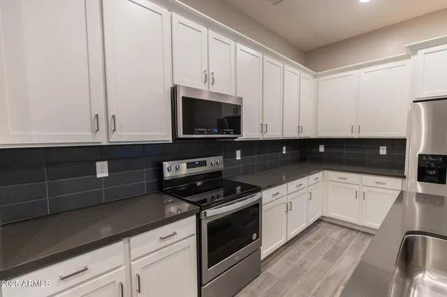 a kitchen with granite countertop a stove sink and microwave