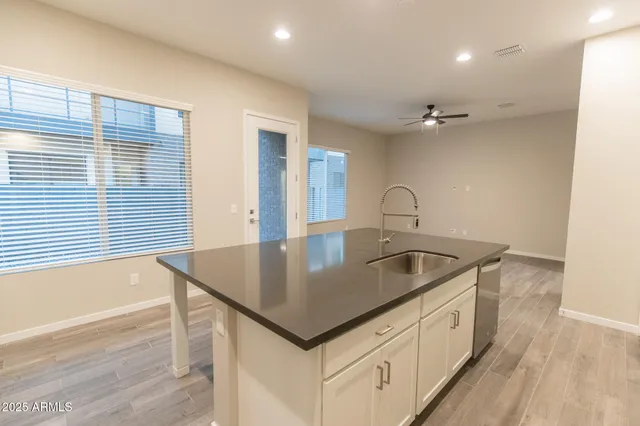 a kitchen with granite countertop white cabinets and black appliances