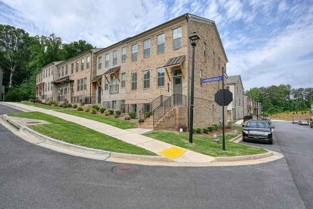 a view of a large white house with a big yard and potted plants